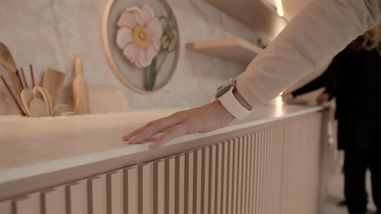 A visitor wearing an Apple Watch touches the wood surfaces inside Casa Alma.